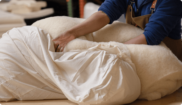 medley worker stuffing wool into a cotton lining