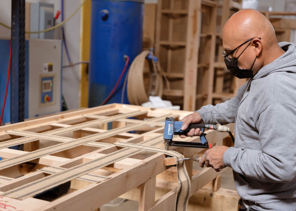 medley craftsperson applying webbing to sofa frame